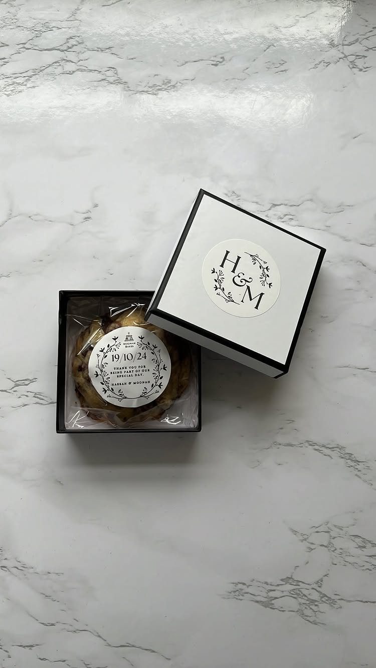 Round cookie in a black gift box with personalized initials on the lid.