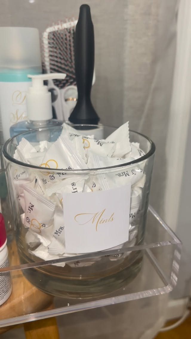Glass bowl filled with wrapped mints and a gold cursive Mints label
