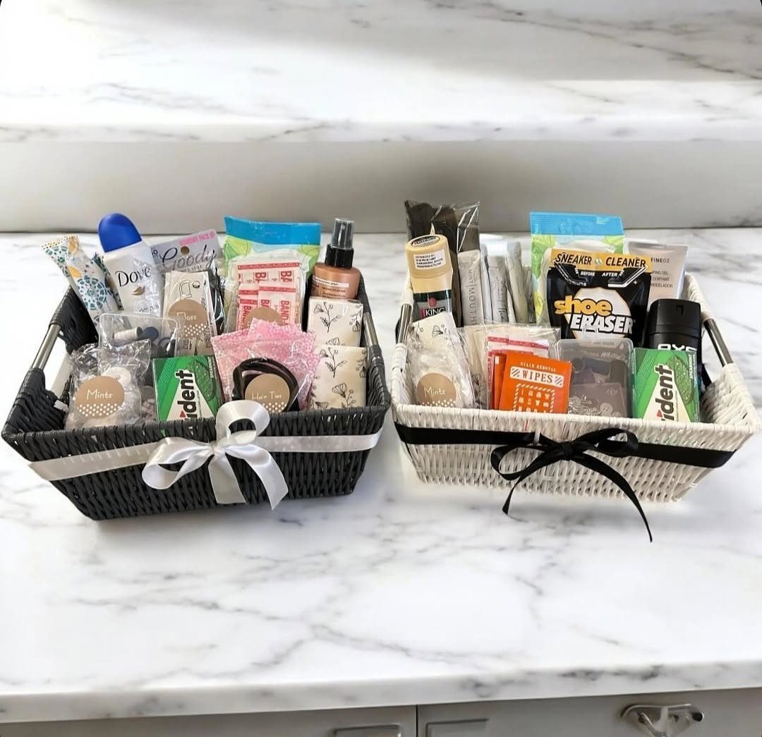 Two wedding bathroom baskets filled with toiletries on a white marble countertop.