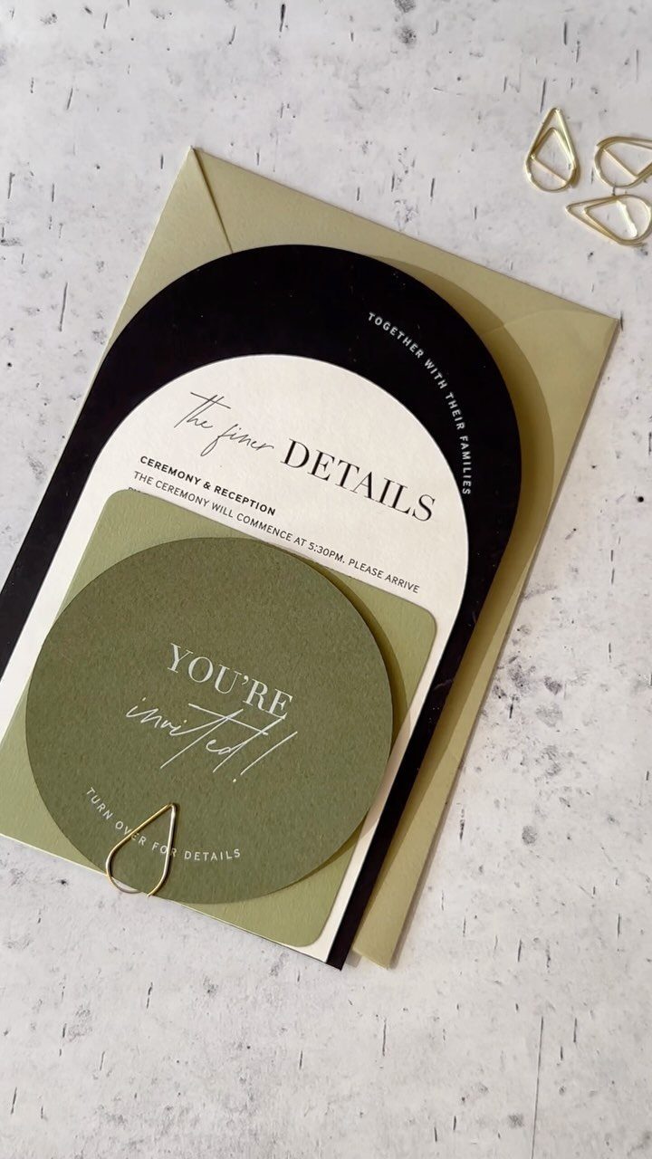 Wedding invitation suite with black, white, and olive green cards on gold envelope.