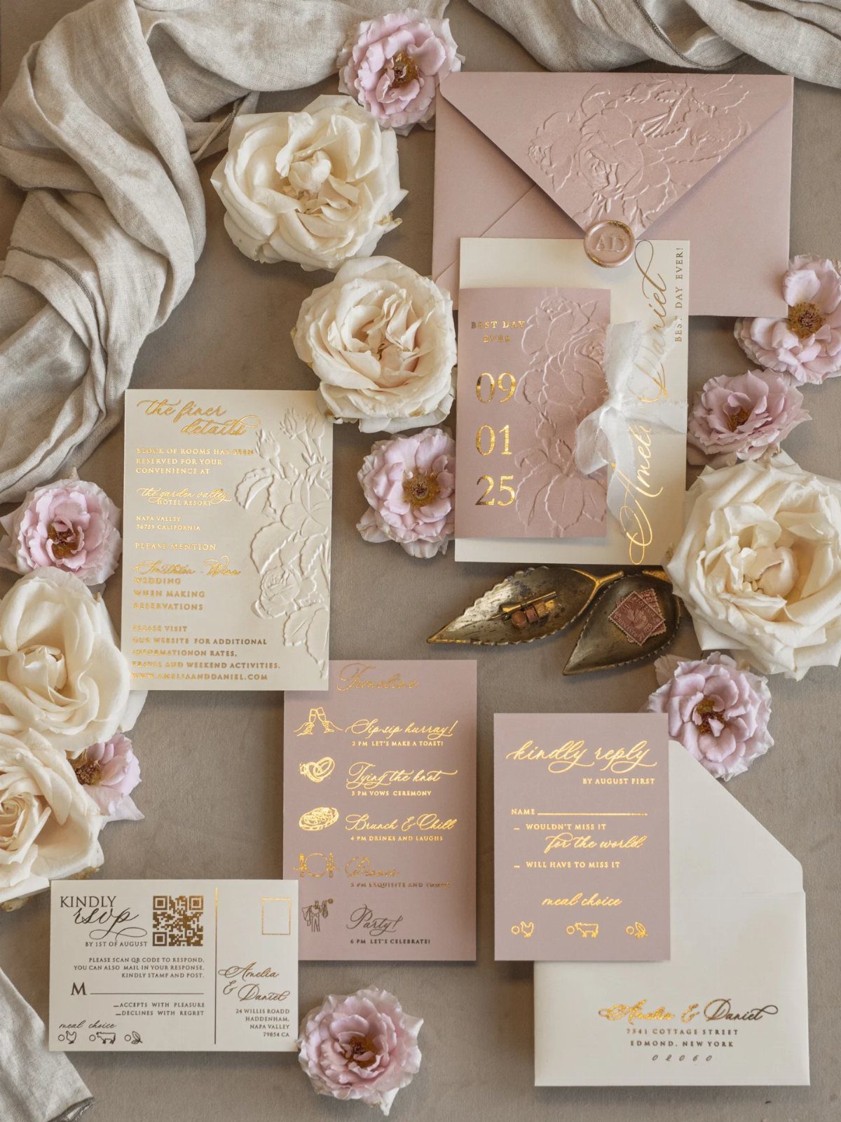 Wedding invitation suite with gold foil lettering and embossed details surrounded by roses.