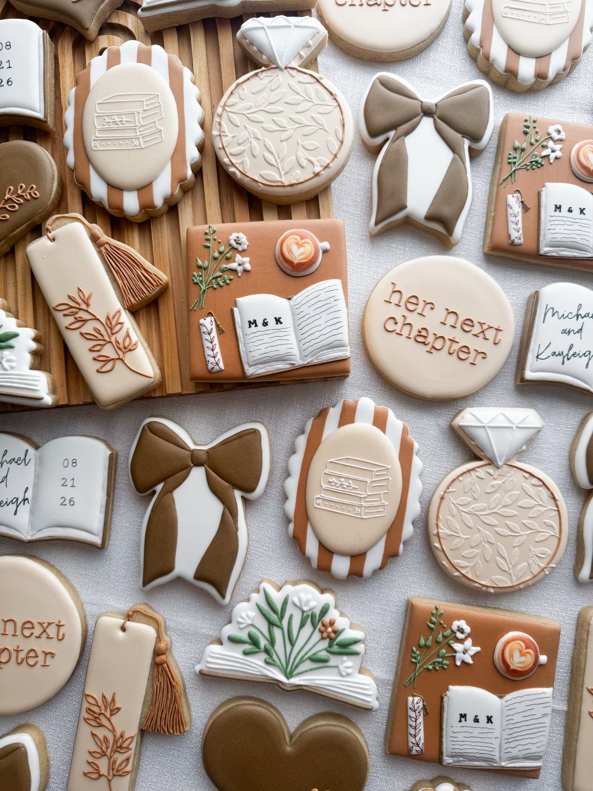 Decorated sugar cookies shaped like open books, stacked books, and wedding rings.