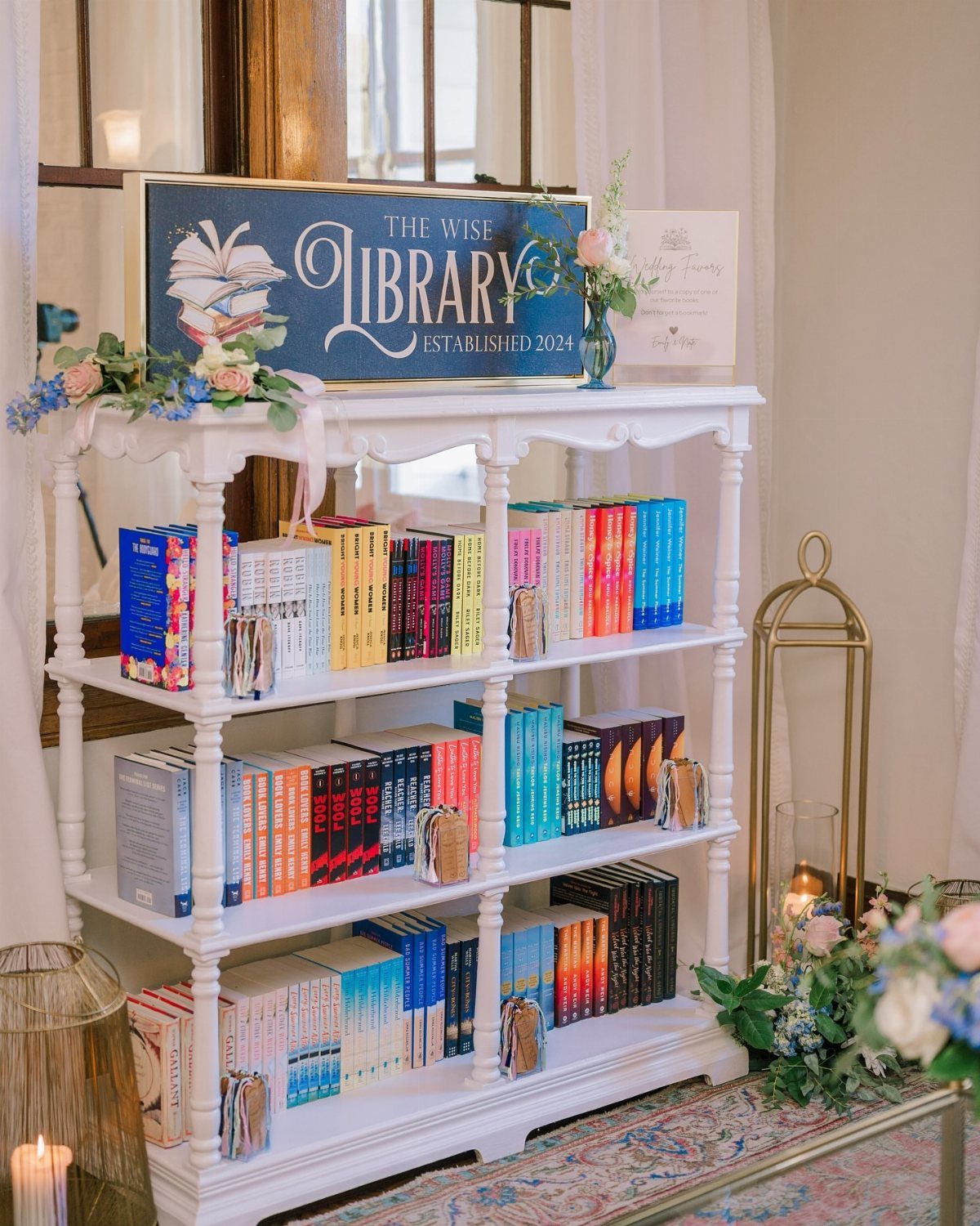 White bookshelf filled with colorful books and a Wise Library sign for guests.