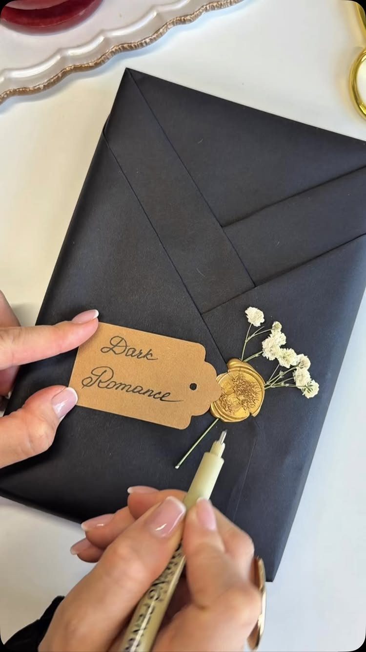 Wrapped book in black paper with a Dark Romance tag and wax seal.