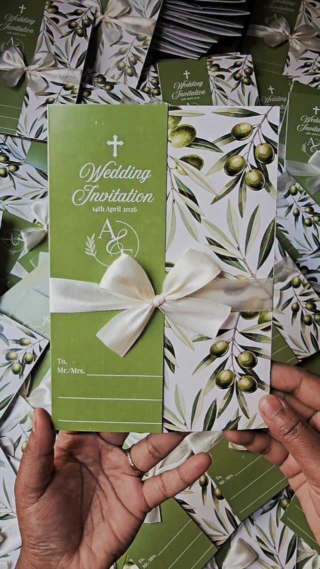 Green and white wedding invitation with a cross and olive branch pattern.