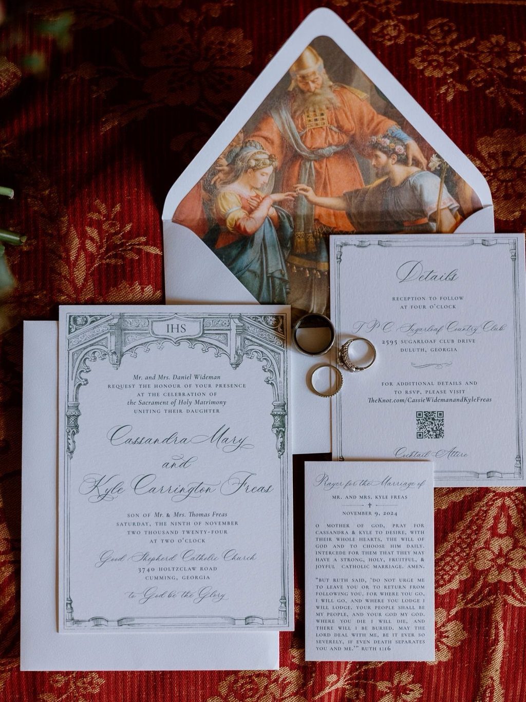 Wedding invitation suite with religious envelope liner and gold rings on red fabric