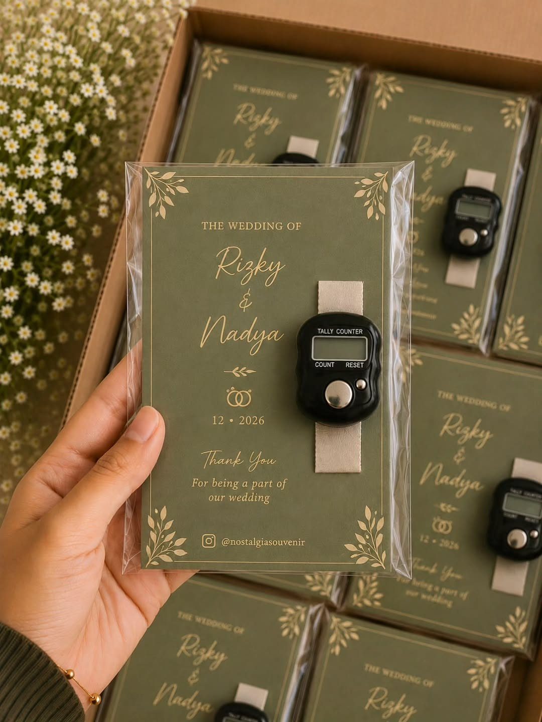 Wedding souvenir with a green card and digital tally counter in plastic packaging.