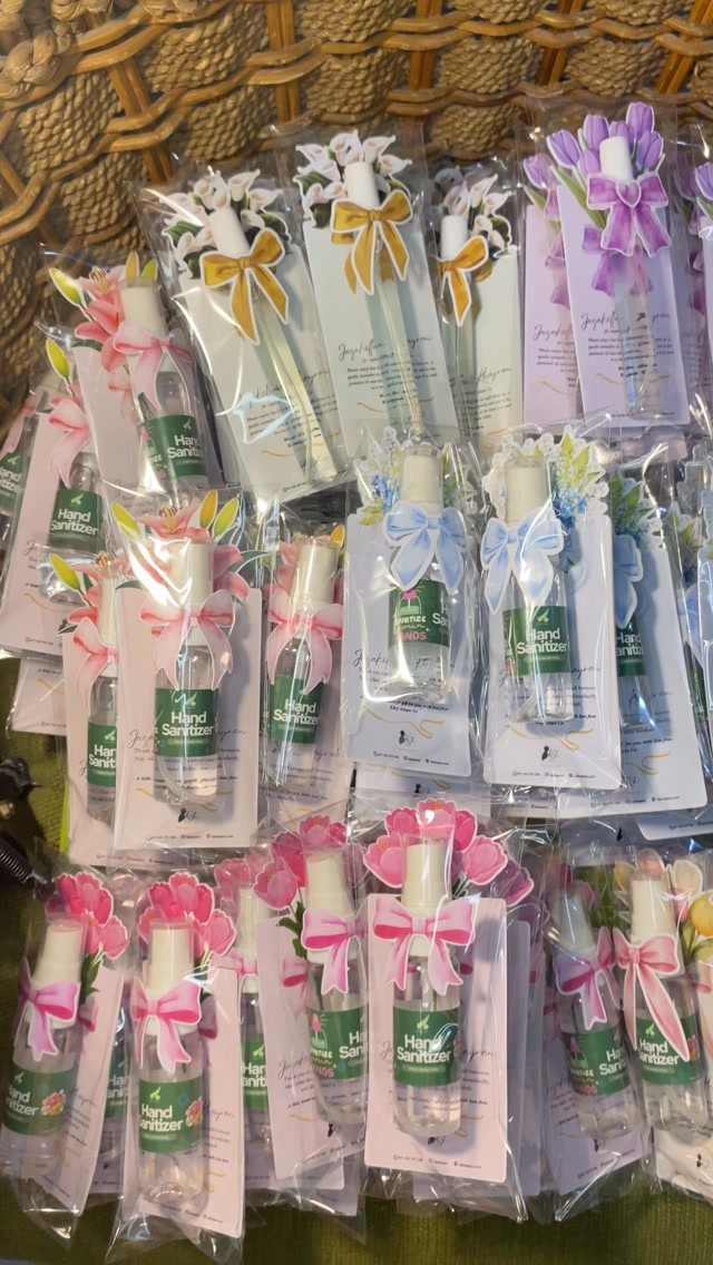 Hand sanitizer bottles with colorful ribbons and decorative cards in a wicker basket.
