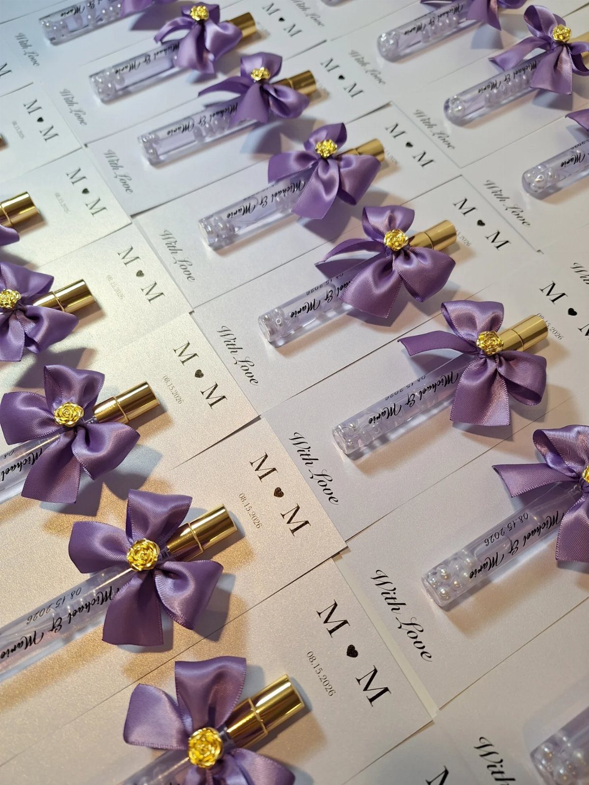 Small tubes of white mints with purple bows on personalized white cards.