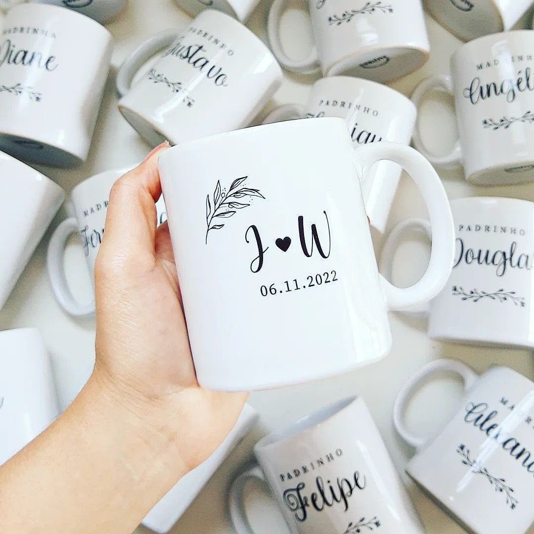White ceramic mugs with personalized names and wedding dates for wedding favors.