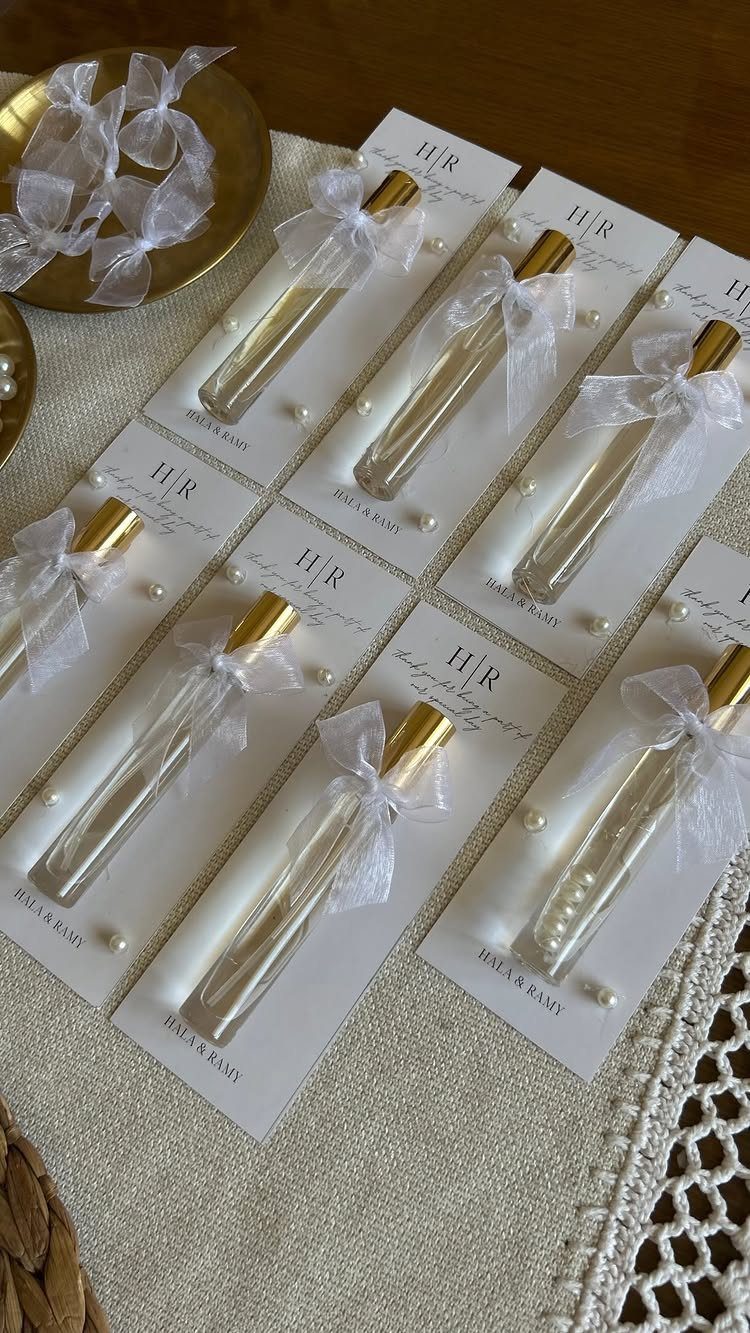 Small honey tubes with gold caps and white bows on personalized cards