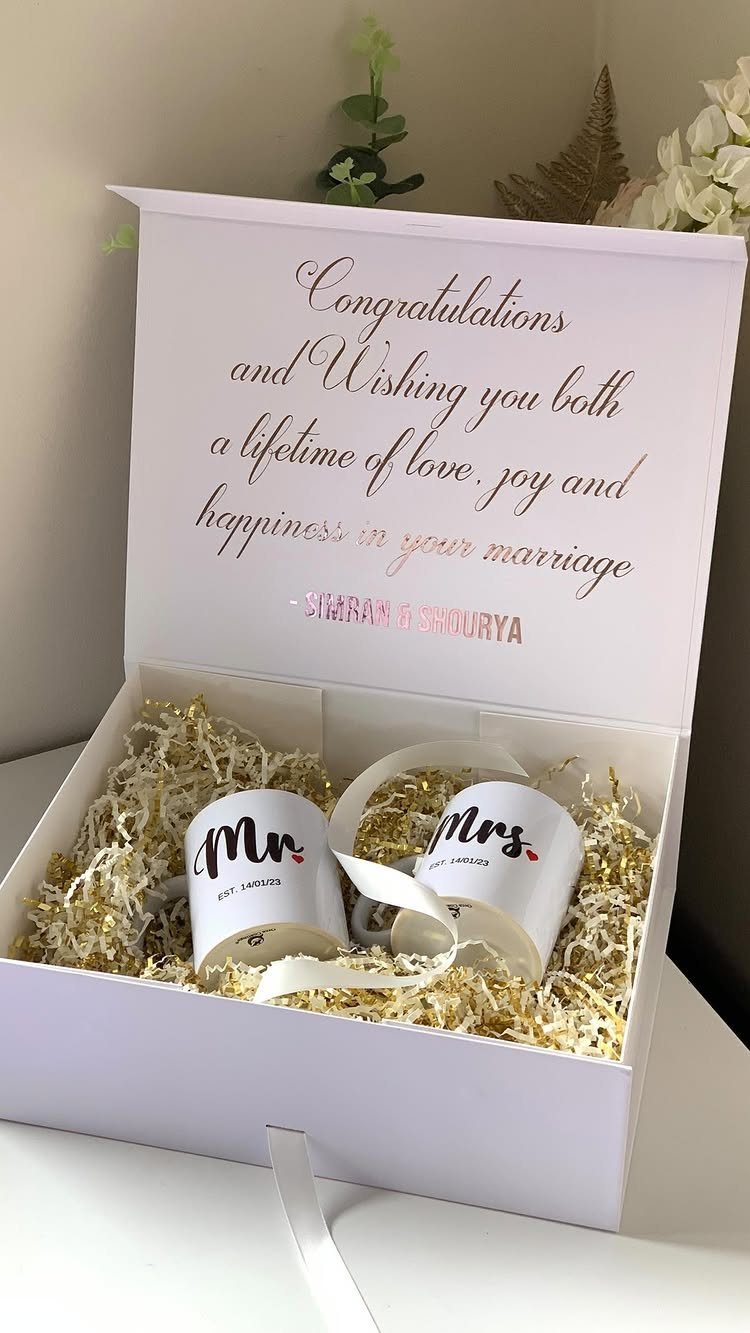 Two white Mr. and Mrs. mugs in a gift box with gold filler.