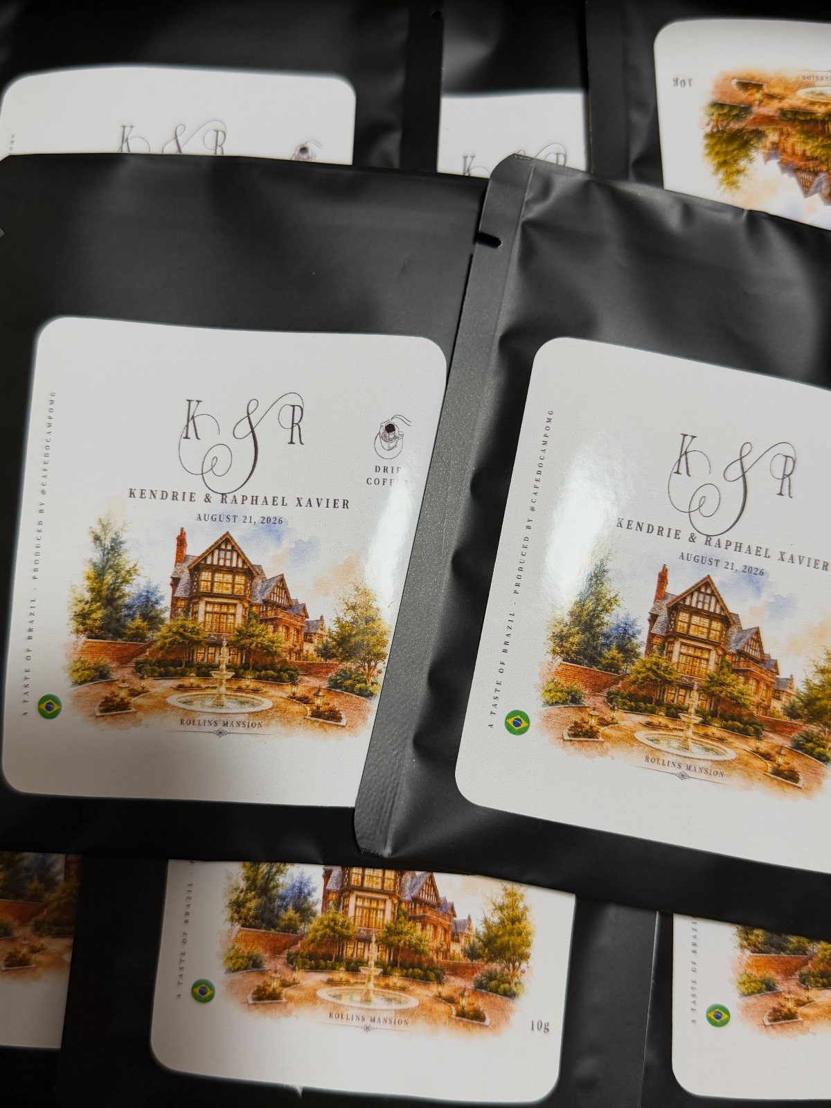 Black coffee pouches with customized white labels featuring a house illustration and monogram.