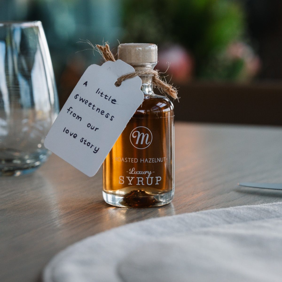 Small bottle of roasted hazelnut syrup with a romantic wedding gift tag.