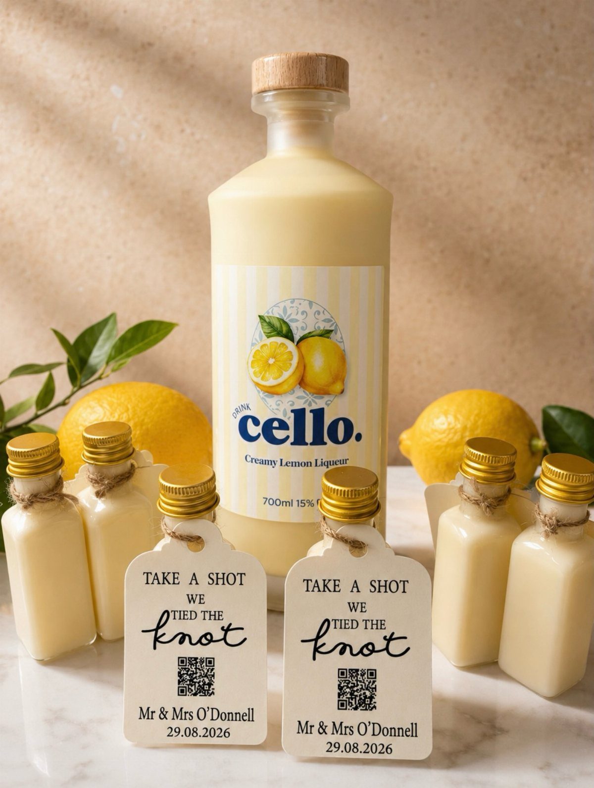 Miniature bottles of creamy lemon liqueur with personalized wedding tags and fresh lemons.