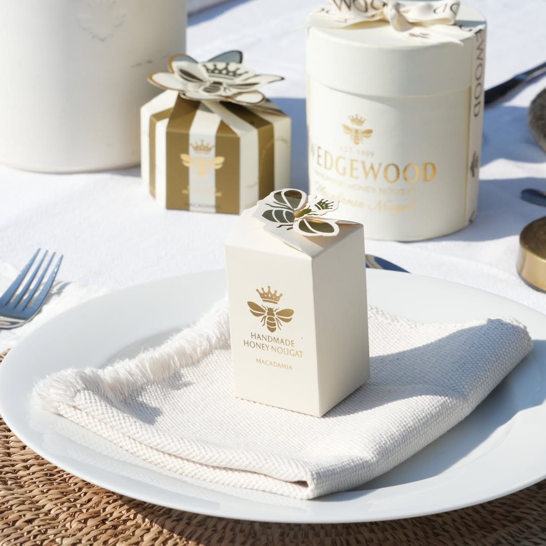 Handmade honey nougat gift boxes and a tin on a white table setting.