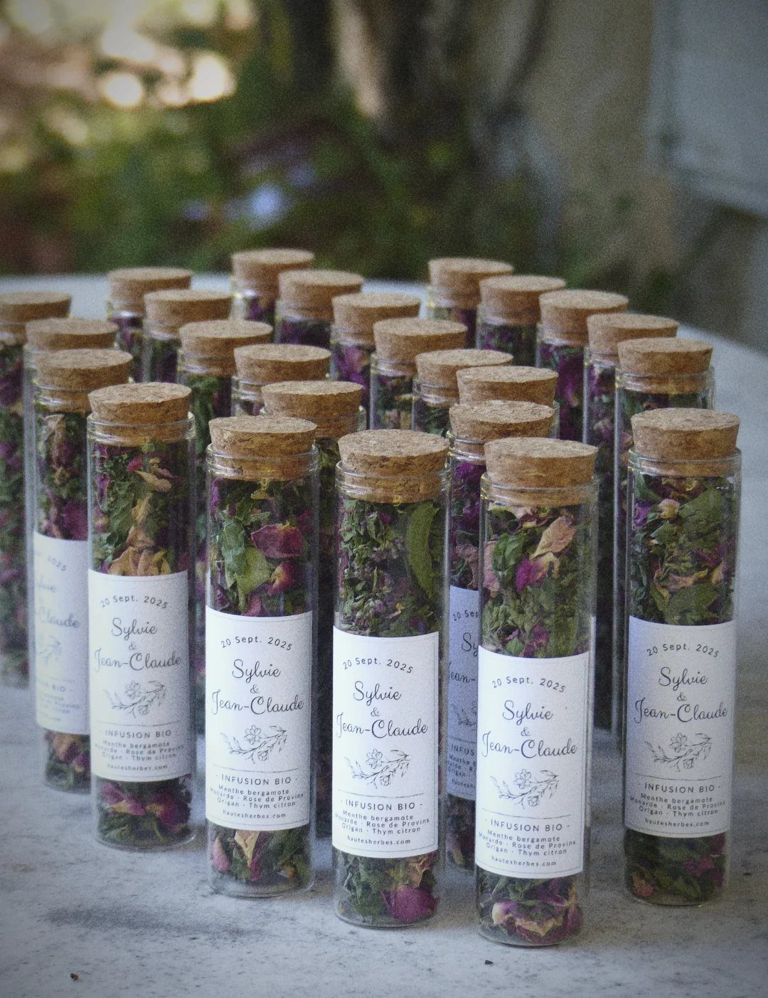 Glass test tubes filled with dried herbal tea blends and personalized wedding labels.