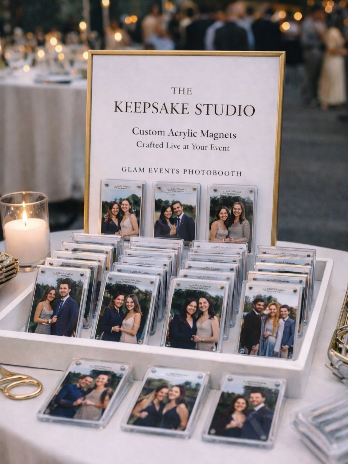 Custom acrylic photo magnets displayed on a white tray next to a sign.