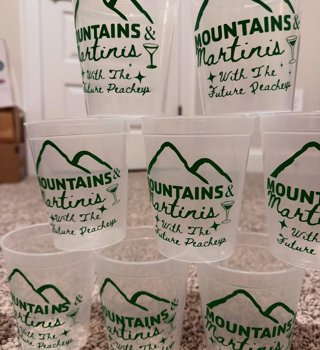 Frosted plastic cups with green mountain graphics and personalized wedding text.