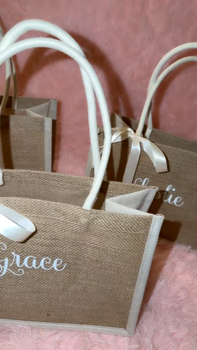 Small burlap tote bags with white handles and personalized names in white cursive.