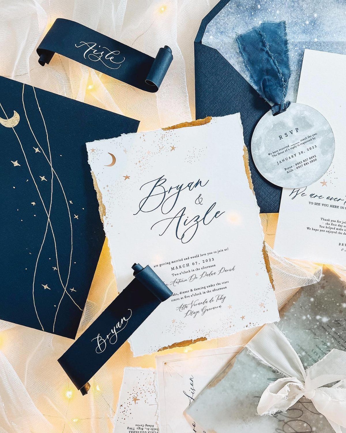 Celestial wedding invitation suite with navy and gold stars, moon, and deckled-edge paper.