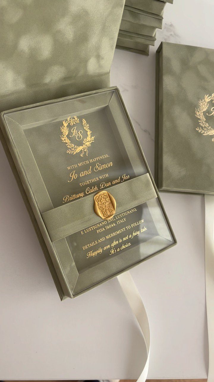 Transparent acrylic wedding invitation with gold text in a sage green box