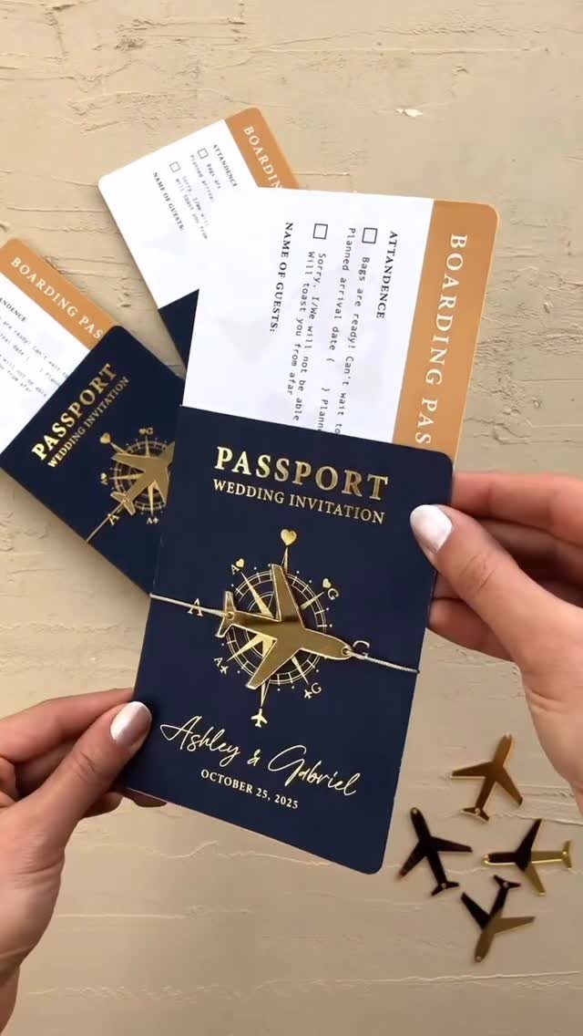 Navy blue passport wedding invitation with gold foil compass and airplane charms.