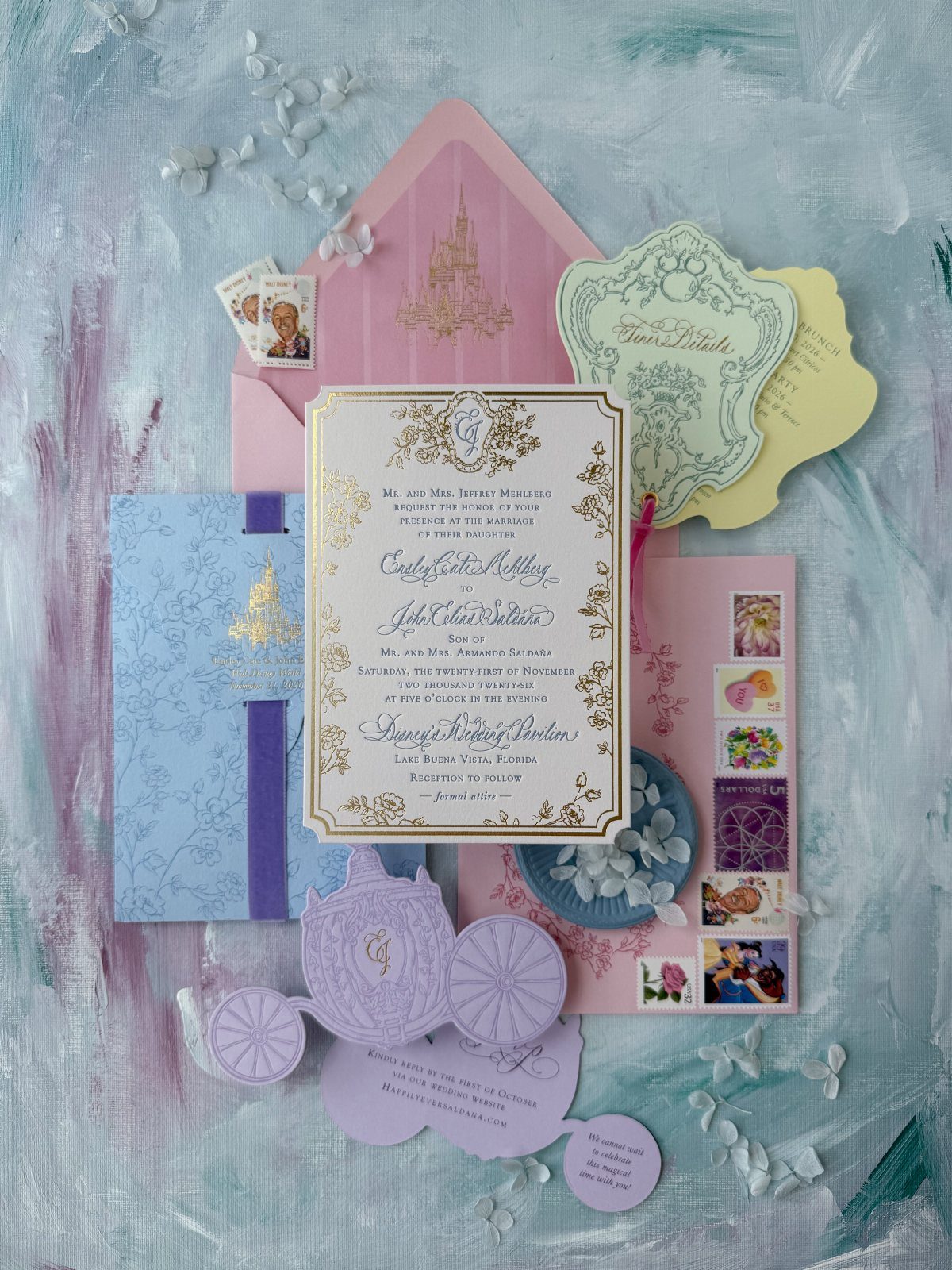 Wedding invitation suite featuring a gold castle silhouette on a pink envelope.