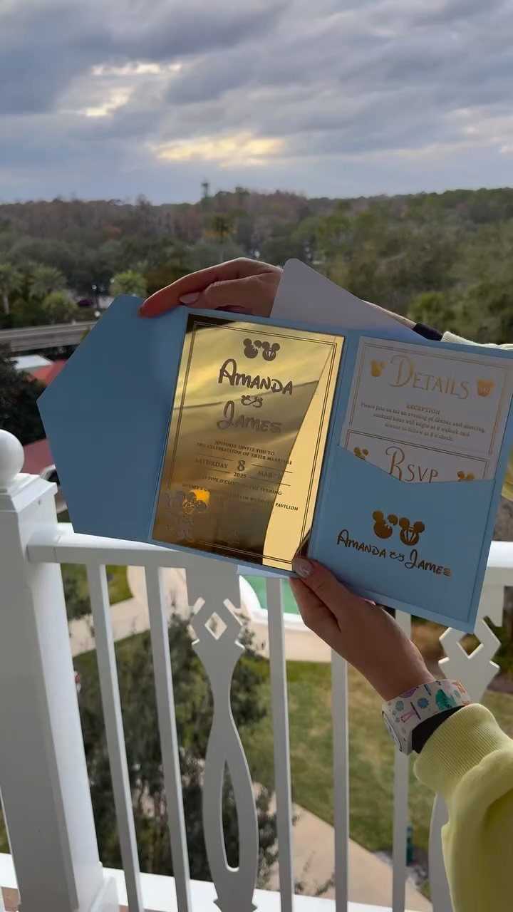 Light blue Disney wedding invitation with gold accents and Mickey Mouse silhouettes.