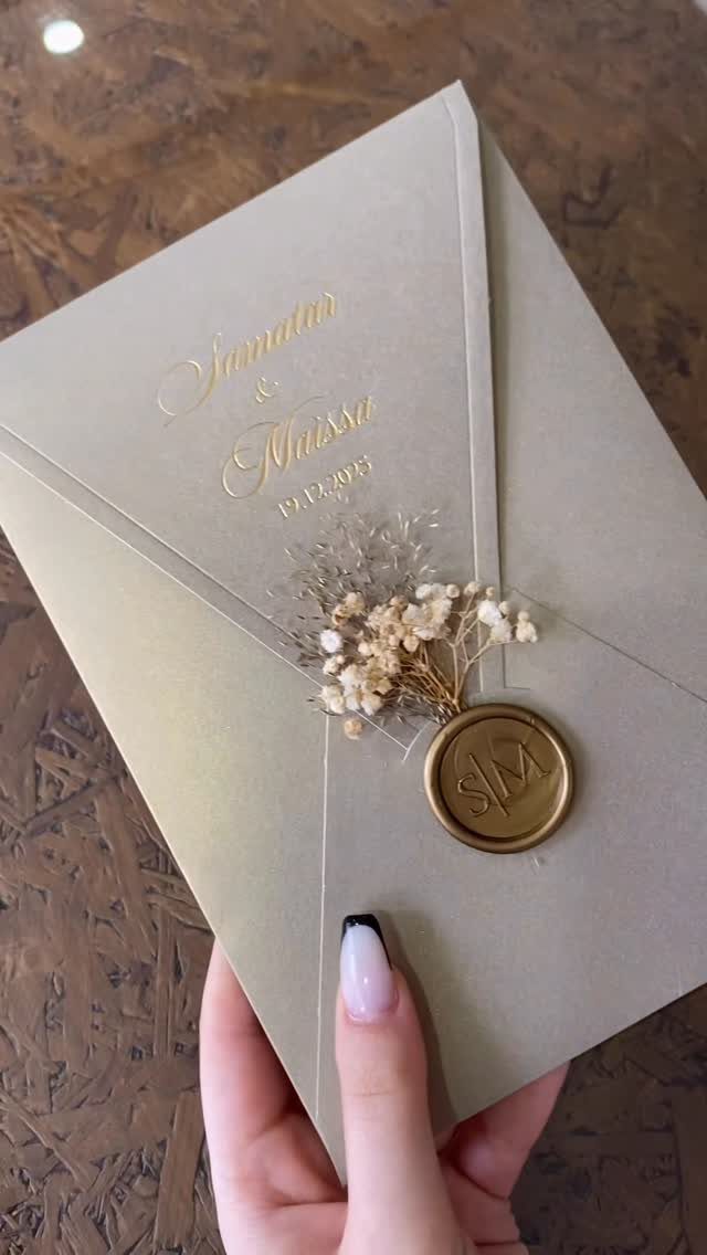 Beige envelope with gold foil calligraphy and a monogrammed gold wax seal.