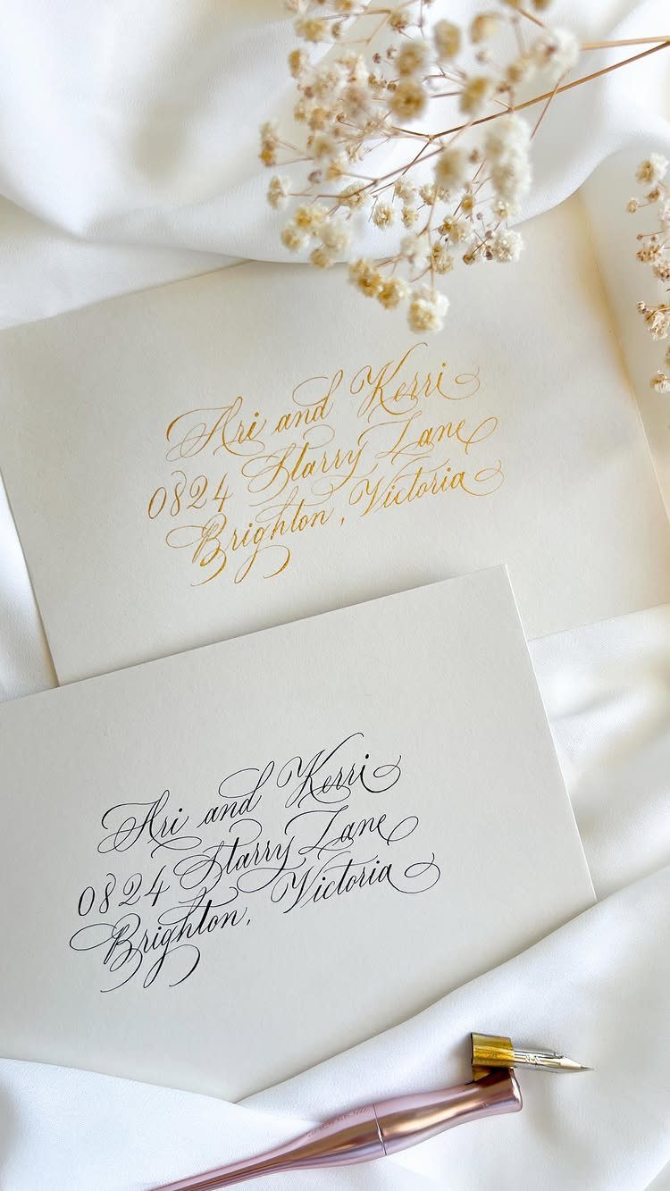 Calligraphy addressed envelopes in gold and black ink with a rose-gold pen.