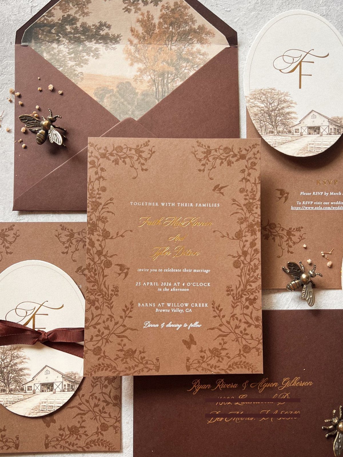 Brown and cream rustic wedding invitations featuring barn illustrations and gold calligraphy.