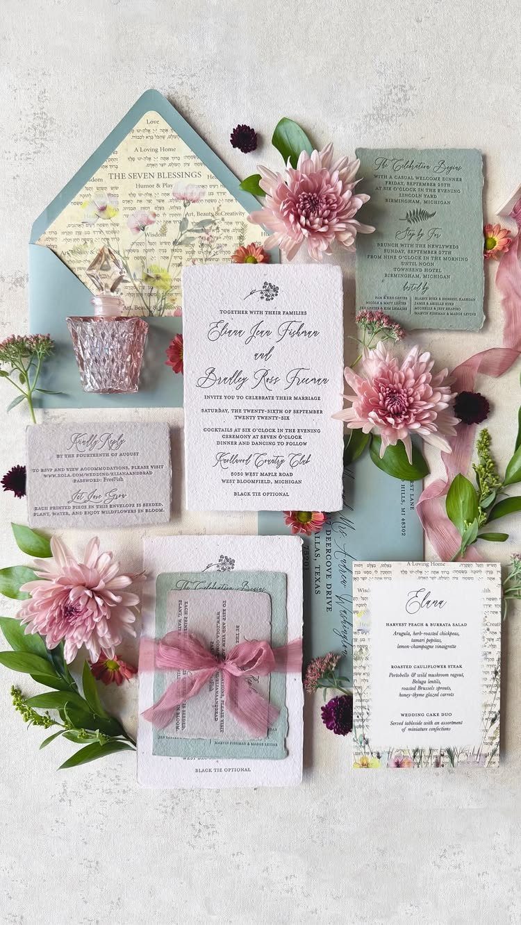 Wedding invitation suite with reply card and envelopes accented by pink chrysanthemums.