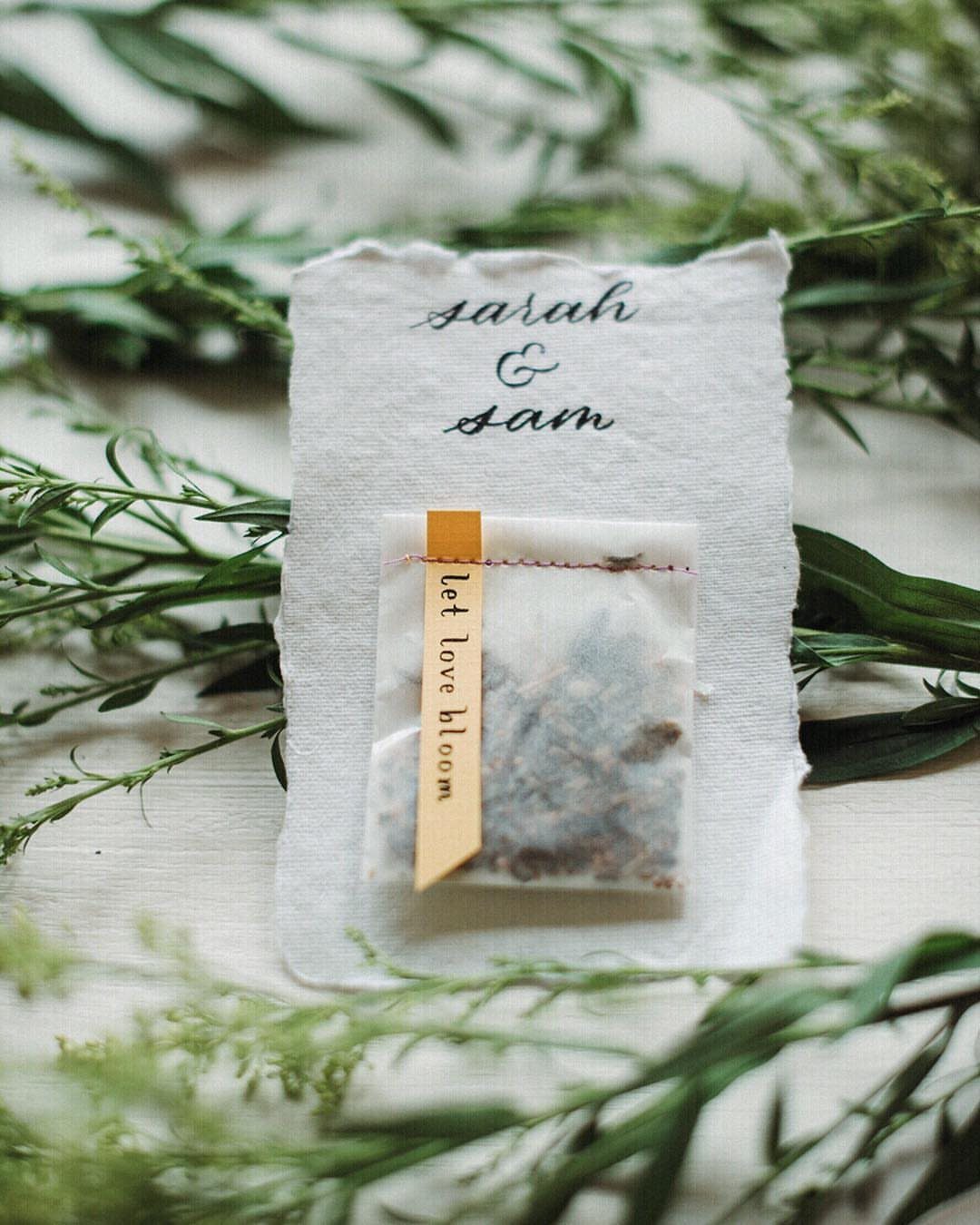 Seed packet attached to a personalized wedding card with a yellow ribbon and greenery.