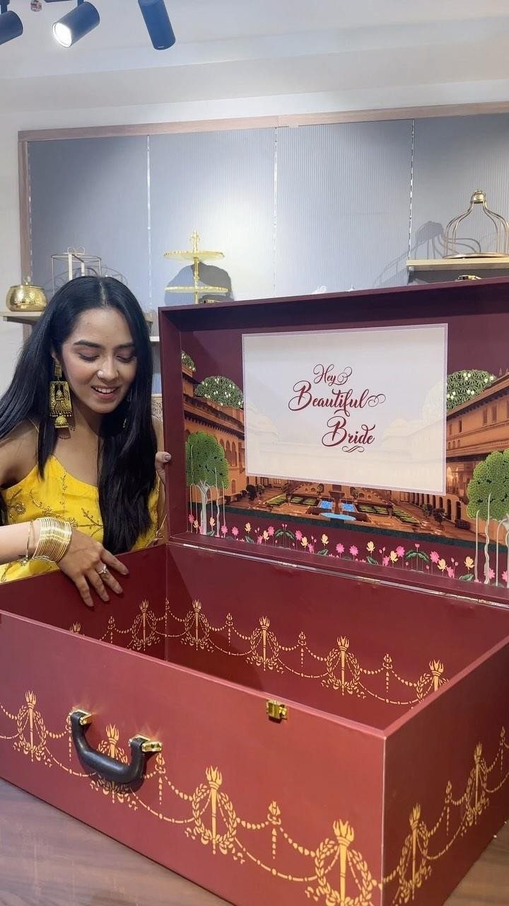 Woman looking into a red and gold ornate keepsake box for a bride.