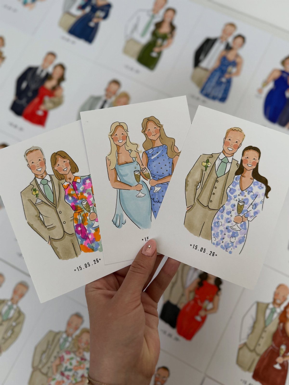 Watercolor illustrated wedding invitation cards held by a hand against a white background