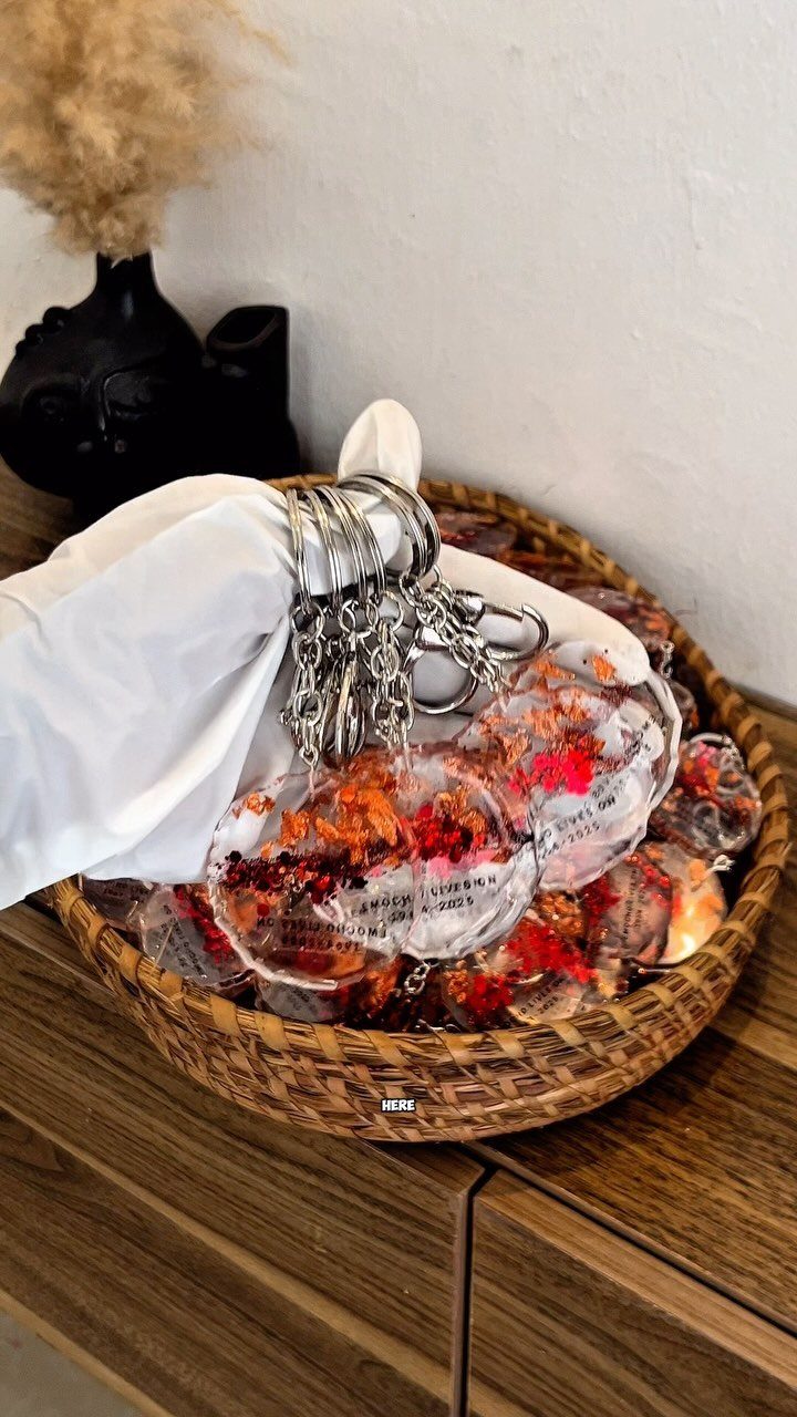 Resin keychains with dried orange flowers in a woven wicker basket
