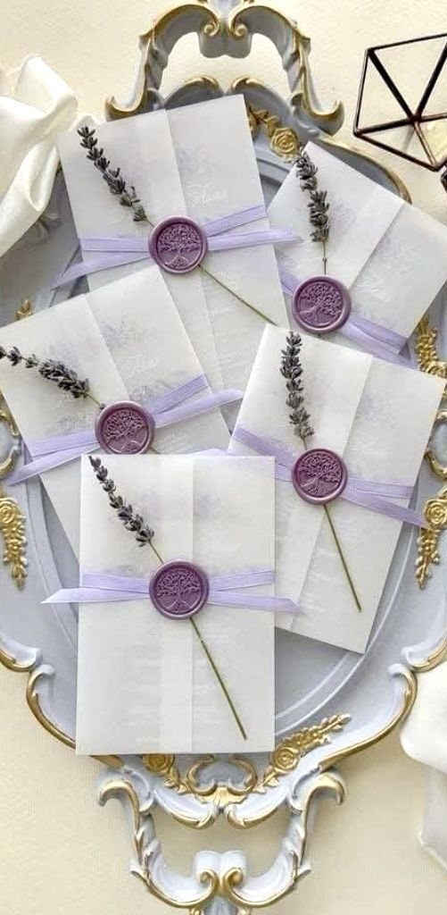 Lavender wedding invitations with purple wax seals and dried lavender on gold tray