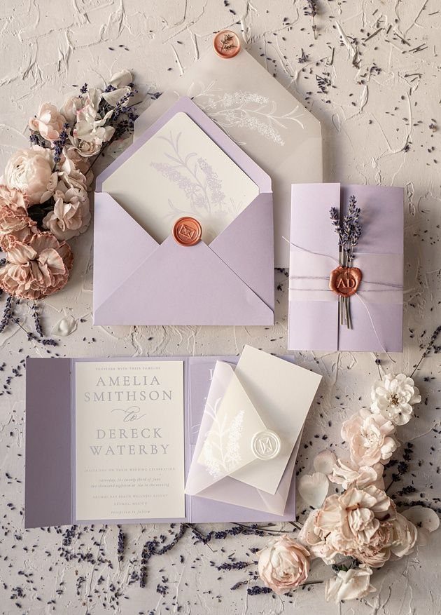 Lavender envelopes and wedding invitations with wax seals and dried lavender sprigs.