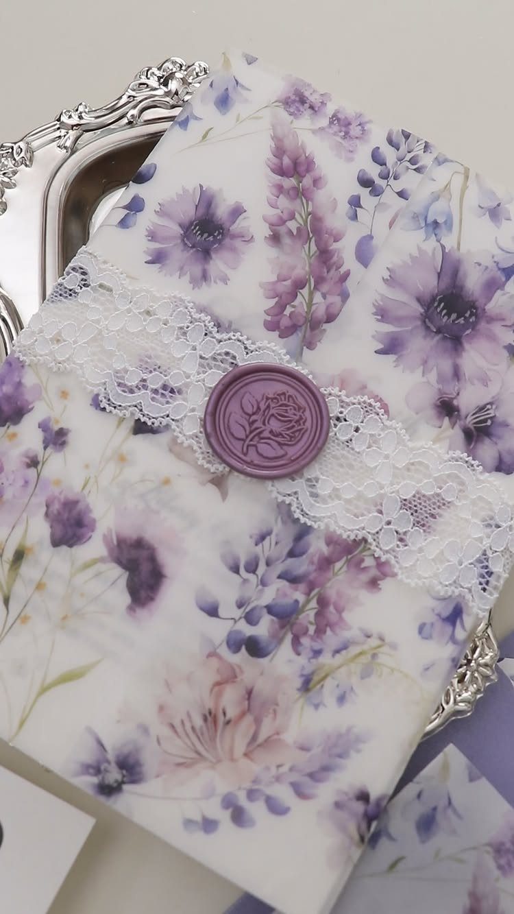 Lavender floral wedding invitation with white lace band and purple wax seal