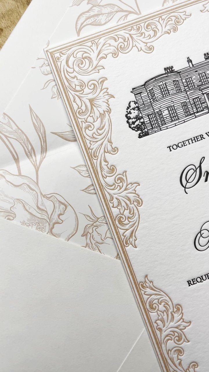 White wedding invitation with gold embossed borders and black elegant typography.