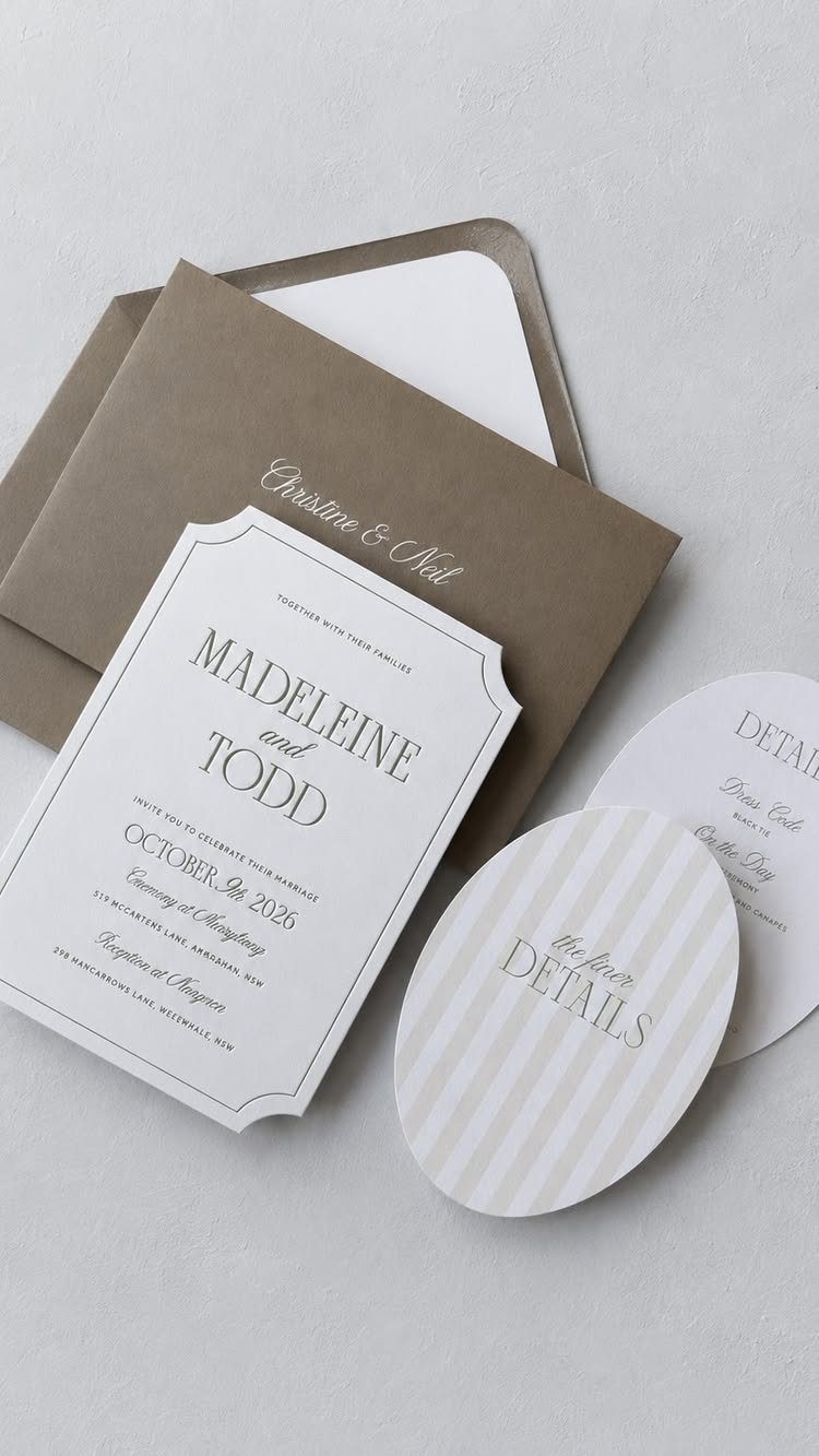 Wedding invitation suite with scalloped white card, brown envelope, and oval detail cards.