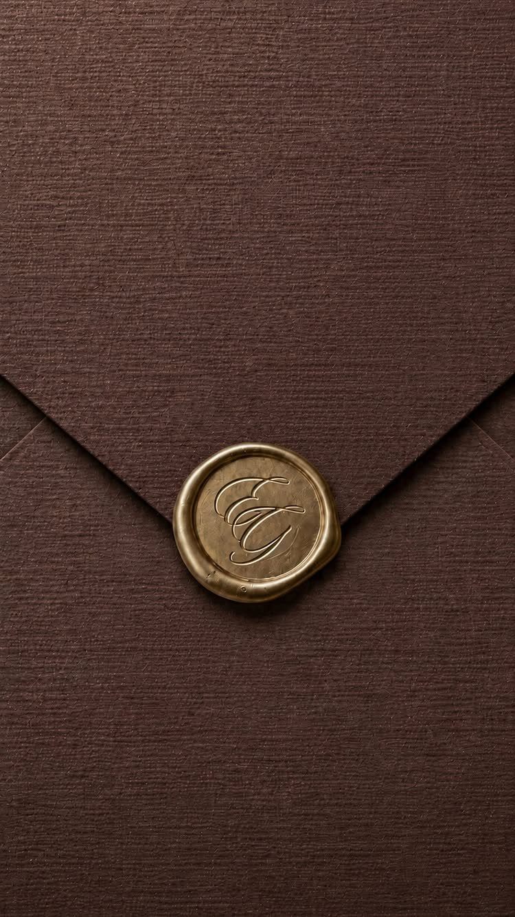 Brown textured envelope with a gold wax seal featuring a cursive monogram.