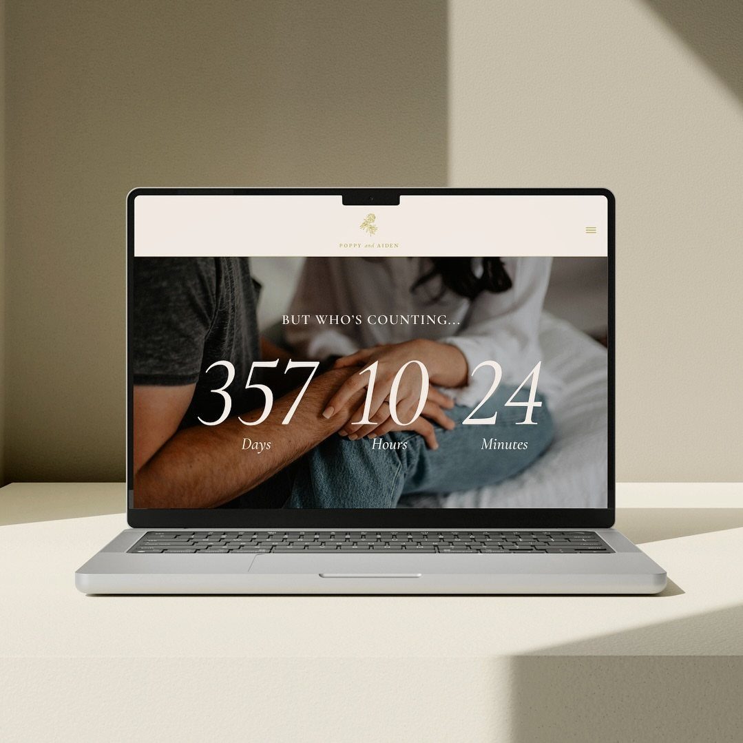 Laptop screen showing a wedding website with a countdown timer and couple's hands.