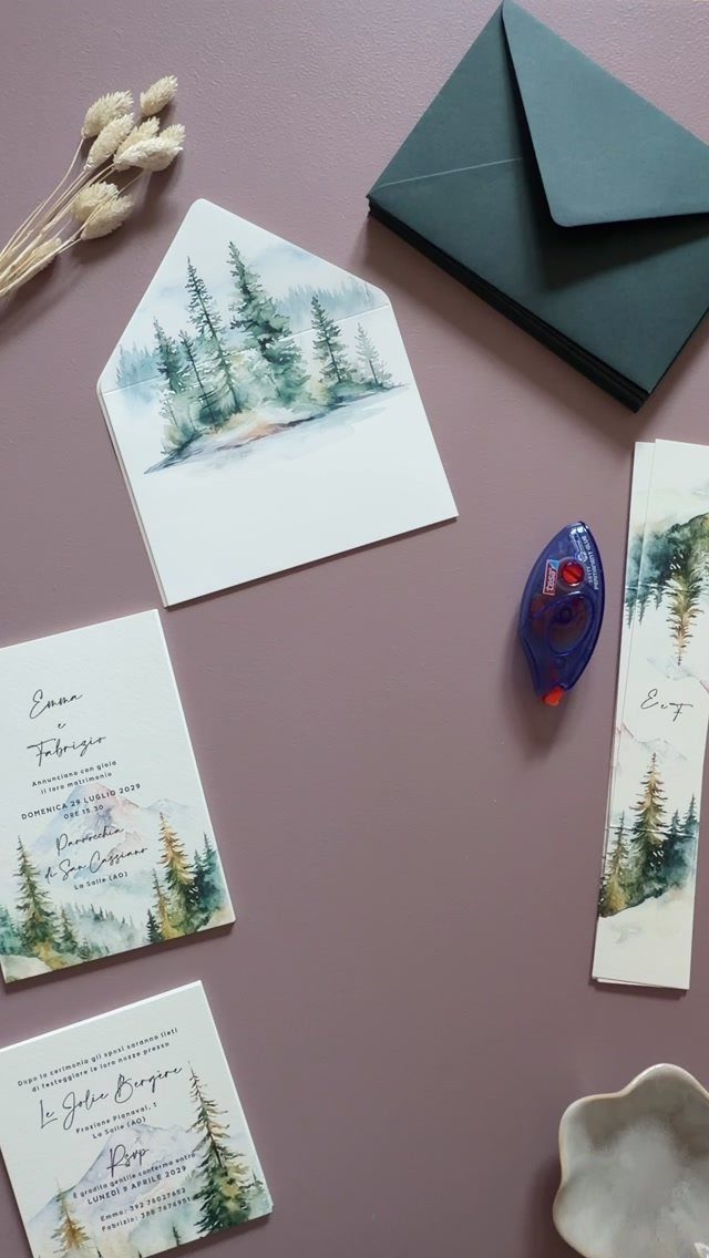 Wedding stationery featuring watercolor pine trees and mountains on a purple background.
