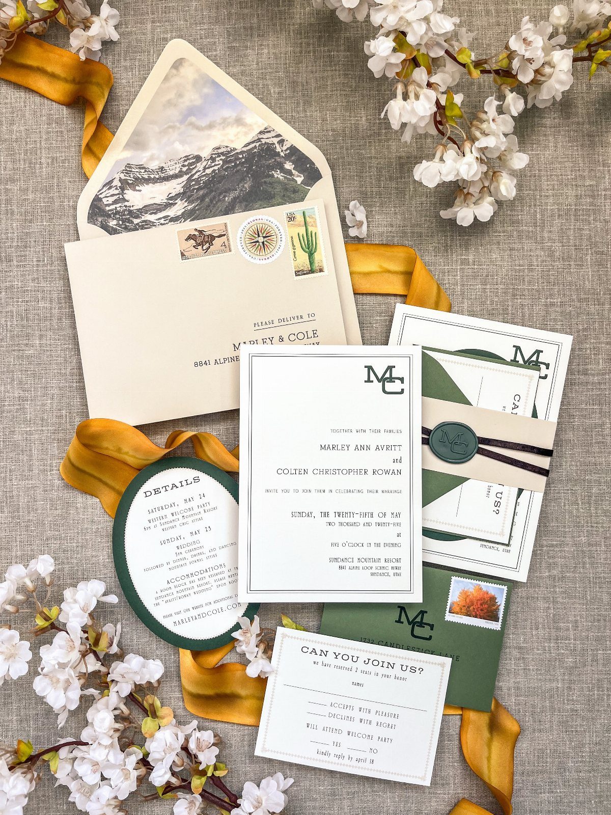 Wedding stationery suite with vintage postage stamps, green accents, and white floral blossoms.