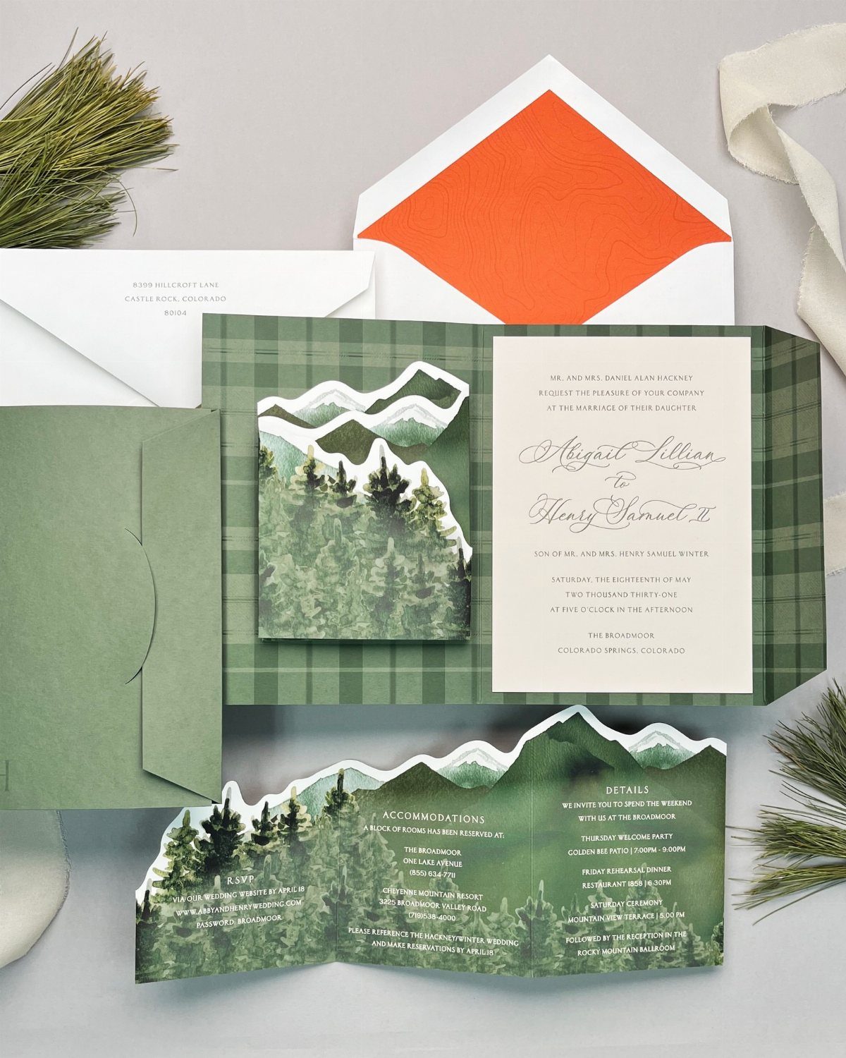 Wedding invitation suite with forest landscapes, green plaid patterns, and an orange envelope liner.