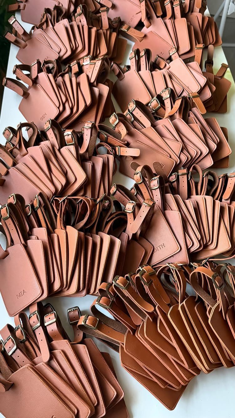 Leather luggage tags in tan and brown colors arranged in neat rows.