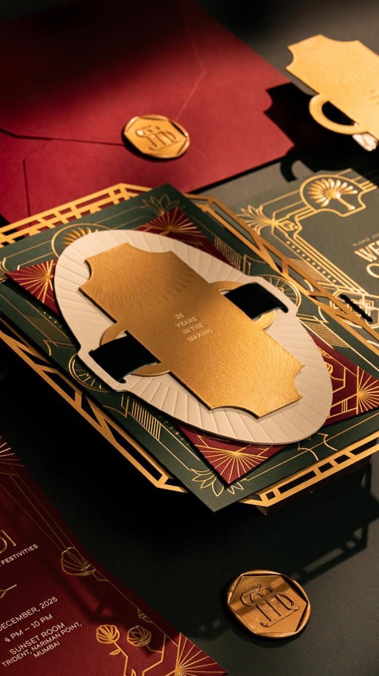 Art Deco wedding invitations with gold geometric patterns on green and red paper.