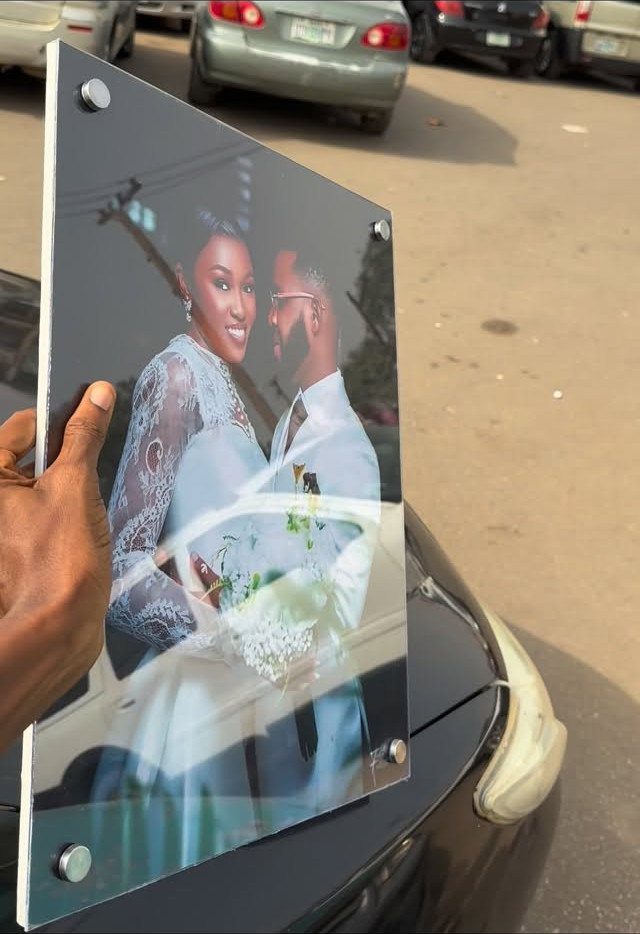 Acrylic plaque featuring a wedding photo of a bride and groom held outdoors.